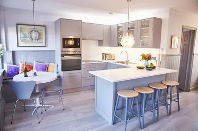 a kitchen with a island with bar stools at SEALOFT, Aldeburgh , Stay in Suffolk in Aldeburgh