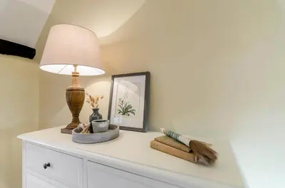 a table with a lamp and a picture on it at 5 Bedroom House in Larling, near Thetford in Norwich