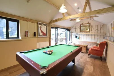 a pool table in a living room with a pool at Yew Tree Farm Barn, Worlingworth in Worlingworth