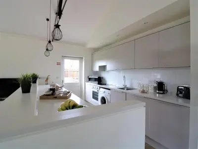 a kitchen with white cabinets and a white counter top at Oak Cottage at Gravel Farm in Stretham