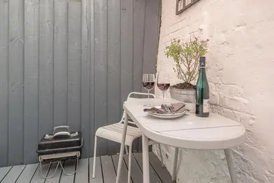 a table with two glasses of wine on a balcony at 232a High Street, Aldeburgh in Aldeburgh