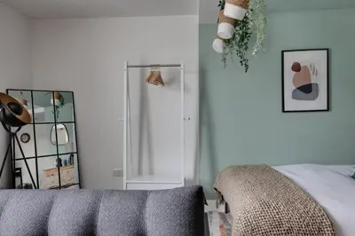 a bedroom with a bed and a mirror at Studio Apartment - Central Chelmsford Location in Chelmsford
