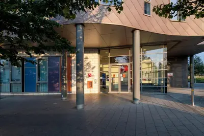 a building with glass windows and a red roof at For Students Only Collegiate Athena Hall Ipswich in Ipswich