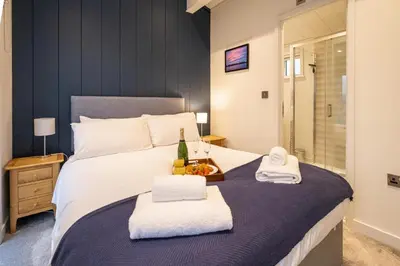 a bedroom with a bed with two towels on it at Beach Lodge - Aldeburgh Coastal Cottages in Sizewell