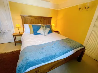 a bedroom with a bed with a wooden headboard at The Peacock Inn in Chelsworth