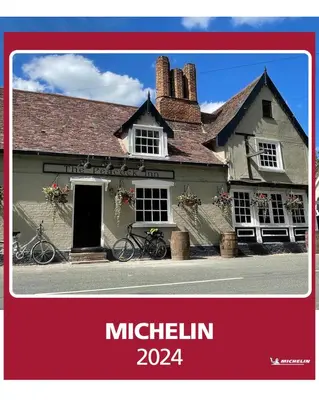 a picture of a building with two bikes parked outside at The Peacock Inn in Chelsworth