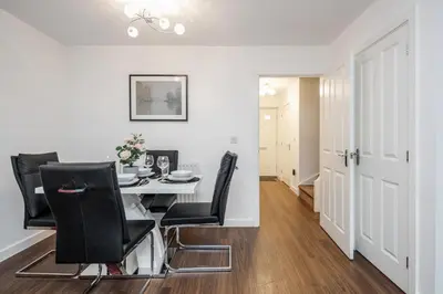 a dining room with a table and black chairs at Stunning 3BR house in Basildon in Basildon