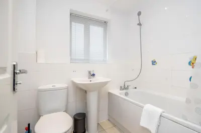 a white bathroom with a toilet and a sink at Stunning 3BR house in Basildon in Basildon