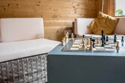 a chess game on a table next to a chair at The Cartlodge Boundary Farm, Framlingham in Woodbridge