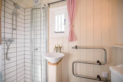 a bathroom with a sink and a shower at Thyme Shepherds Hut Boundary Farm, Framlingham in Woodbridge