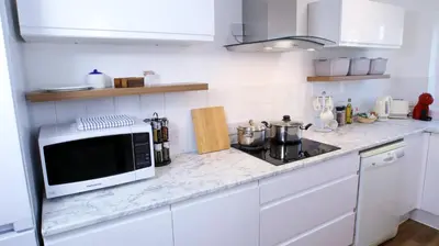 a white kitchen with a microwave and a stove at FREE parking, Central Location,1 Bedroom Apartment near Tattersalls in Newmarket
