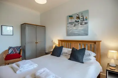 a bedroom with two beds and a chair in it at 2 Bed in Blythburgh oc-wag2 in Blythburgh