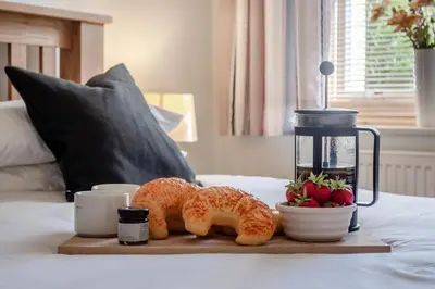 a tray with croissants and fruit on a bed at 2 Bed in Blythburgh oc-wag2 in Blythburgh