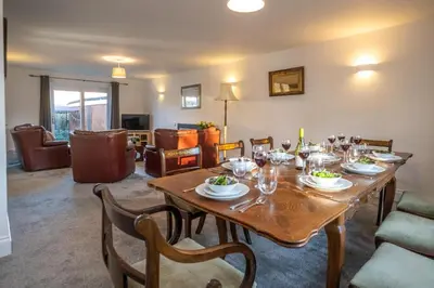 a dining room with a table with wine glasses at 4 The Birches - Aldeburgh Coastal Cottages in Aldeburgh