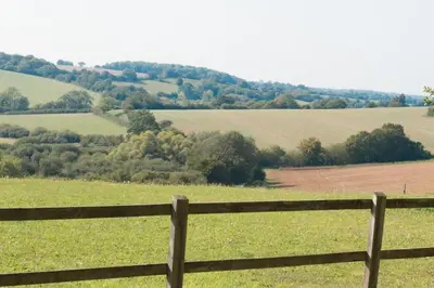 a wooden fence in front of a green field at The Old Steam Mill, luxury, spacious, beautiful grounds, stunning location in Hartest