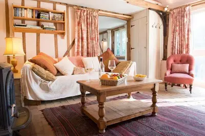 a living room with a couch and a table at Bromans Barn a beautiful cottage by the Sea and Cudmore Nature Reserve in West Mersea