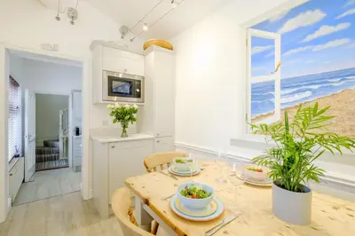 a dining room with a table and a window at The Old Bakery - Aldeburgh Coastal Cottages in Aldeburgh