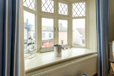 a window with a bucket on a window sill at The Old Bakery - Aldeburgh Coastal Cottages in Aldeburgh