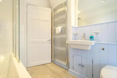 a bathroom with a sink and a toilet and a tub at The Old Bakery - Aldeburgh Coastal Cottages in Aldeburgh