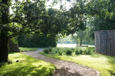 a gravel path in a park with a tree at Snow Cottage laid back style with footpaths to a great Macro Brewery Pub in Edwardstone