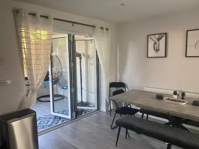 a dining room with a table and a sliding glass door at •11 The Nook in Wivenhoe