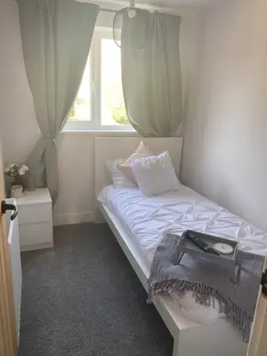 a small bedroom with a bed with a window at •11 The Nook in Wivenhoe