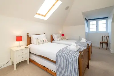two twin beds in a bedroom with a skylight at Gun Lodge - Aldeburgh Coastal Cottages in Aldeburgh