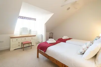 two beds in a attic bedroom with a window at Gun Lodge - Aldeburgh Coastal Cottages in Aldeburgh