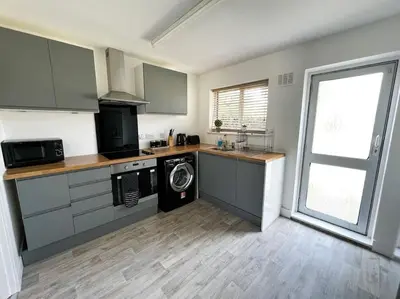 a kitchen with a washer and a washing machine in it at Starview Apartment - Hawthorne in Colchester