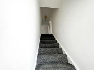 a stairway leading up to a white wall at Starview Apartment - Hawthorne in Colchester