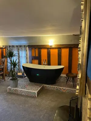 a large bath tub sitting in a room at The Hole In The Wall in Little Wilbraham