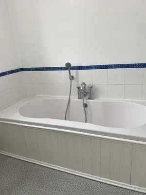 a bath tub with a faucet in a bathroom at Stansted Airport Guest Rooms in Bishops Stortford