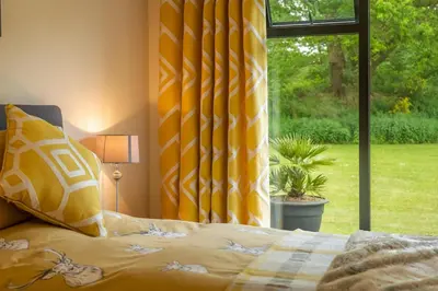a bedroom with a bed and a large window at The Lodge, Wherstead in Wherstead