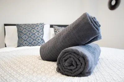 a pile of towels sitting on top of a bed at Townhouse for Professionals (5 Bedroom 5 Ensuite) in Ipswich