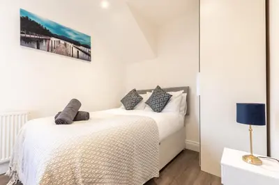 two beds in a bedroom with white walls at Townhouse for Professionals (5 Bedroom 5 Ensuite) in Ipswich