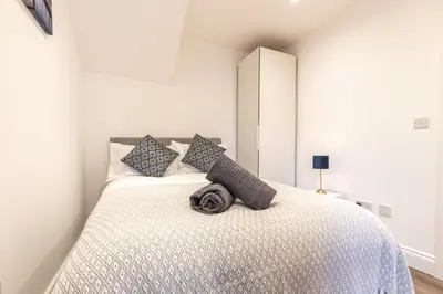 a bedroom with a bed with a white bedspread at Townhouse for Professionals (5 Bedroom 5 Ensuite) in Ipswich