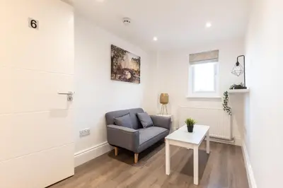 a living room with a chair and a table at Townhouse for Professionals (5 Bedroom 5 Ensuite) in Ipswich