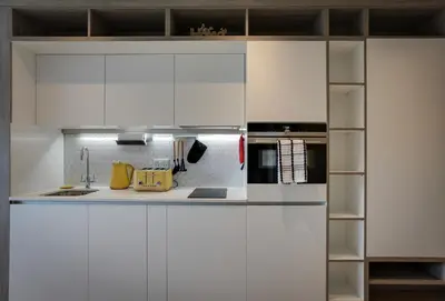 a kitchen with white cabinets and a sink at Kings Road Apartments in Brentwood