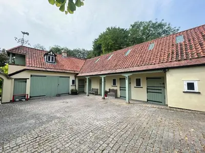 a carriage house with two garages and a driveway at Charming Annexe in a rural setting in Newton