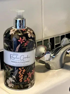 a bottle of soap sitting on a sink next to a faucet at Charming Annexe in a rural setting in Newton