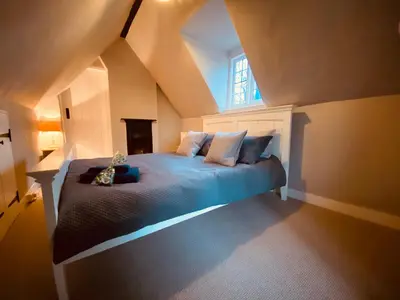 a bedroom with a bed with blue sheets and a window at Charming Annexe in a rural setting in Newton