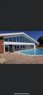 a large building with a swimming pool in front of it at DaisyChain 2 Getaways - The perfect place to Stay - Play - Getaway in East Mersea