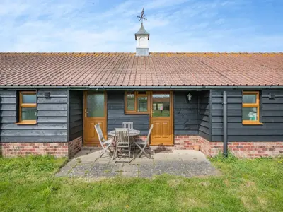 a house with a table and chairs in front of it at Peartree Cottage in Saint Osyth