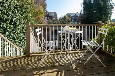 a table and two chairs sitting on a deck at Drake House in Aldeburgh