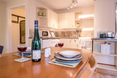 a bottle of wine sitting on a table with two glasses at The Woodshed, Benhall in Saxmundham