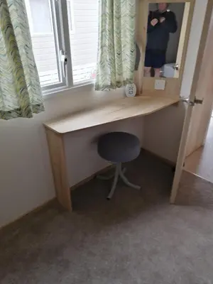 a desk with a chair in a room with a mirror at 709 Seawick in Jaywick Sands
