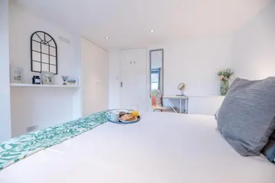 a bedroom with a white bed with a pillow at Lily Cottage, Leiston in Leiston