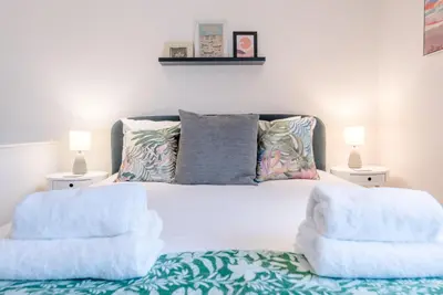 a bedroom with a white bed with two pillows at Lily Cottage, Leiston in Leiston