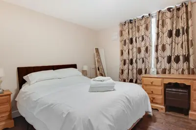 a bedroom with a white bed and a wooden dresser at 3 Bed in Great Waldingfield oc-ac2 in Great Waldingfield