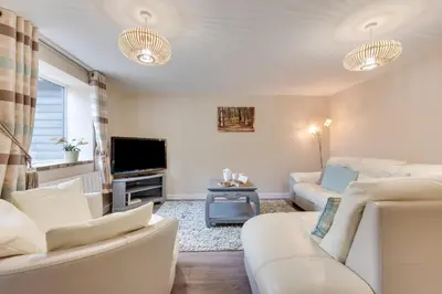 a living room with white furniture and a flat screen tv at 2 Bed in Great Waldingfield oc-ac3 in Great Waldingfield